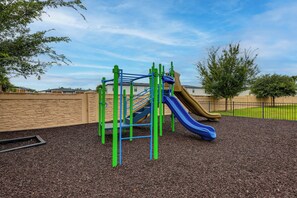 Ein Spielplatz mit Rutsche und Klettergerüsten.