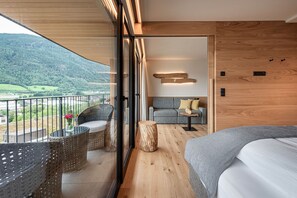 Een modern interieur met balkon, houten vloer en een bank met kussens.