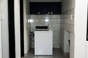 A compact kitchen with a white refrigerator, a microwave, and dark cabinets. - Single Room with Shared Bathroom 1 (Johannesburg)