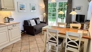 A compact living space with a kitchenette, a dining area, and a sofa.