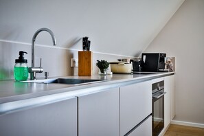 Eine moderne Küche mit integriertem Spülbecken, einer Kaffeemaschine und einem Messerblock.