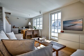 Ein zeitgemäßer Wohnraum mit Essbereich, Küche und einem großen Fenster mit Blick.