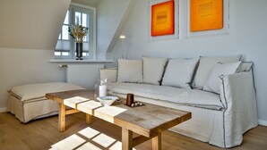 En moderne stue med et træbord, en sofa og et vindue med udsigt.