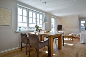 Ett modernt kök med ett matbord, stolar och en tv.