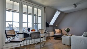 Un loft moderno con comedor, asientos y vistas amplias a través de grandes ventanales.