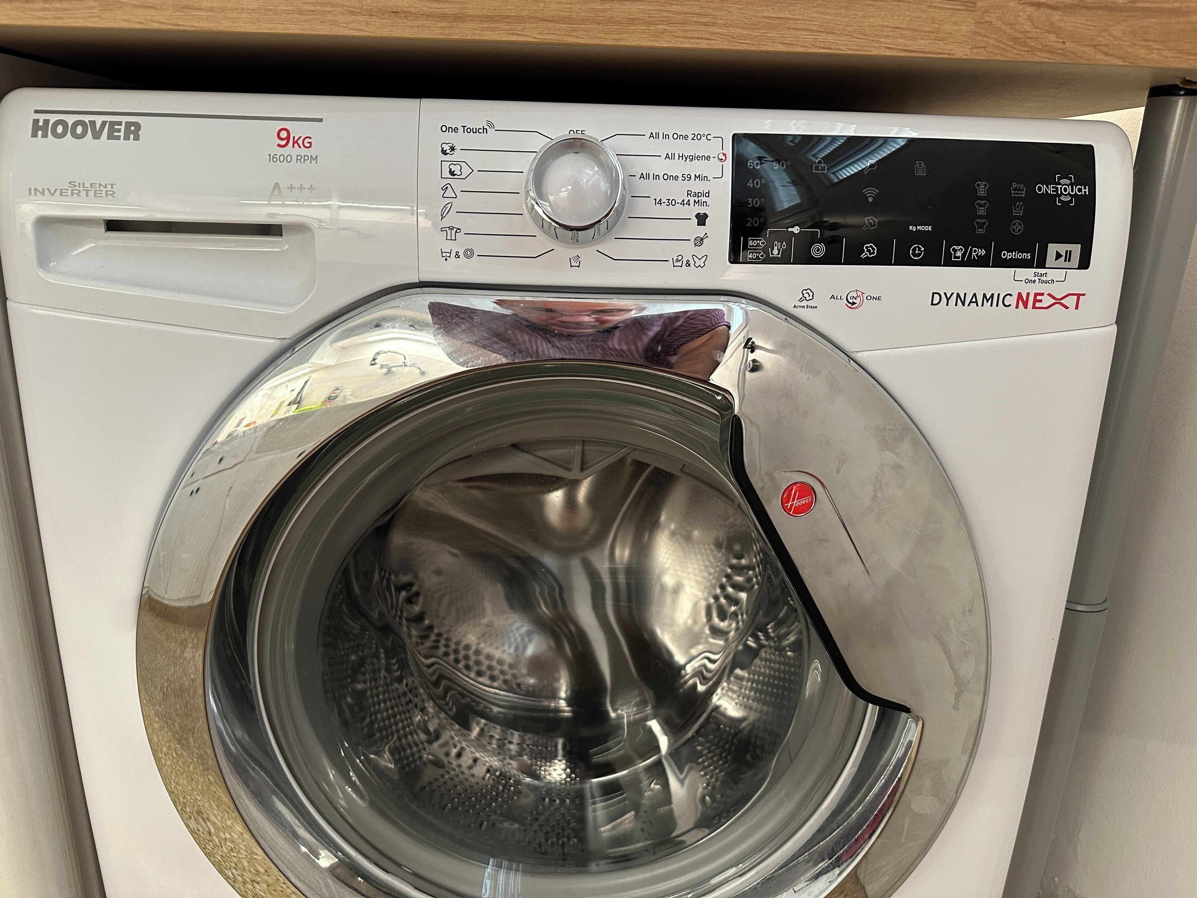 Vue de face d’un lave-linge HOOVER blanc, d’une capacité de 9 kg, doté d’un panneau de commande et d’une porte transparente.