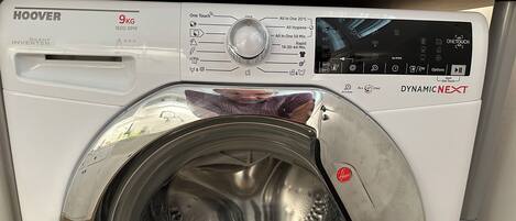 Vue de face d’un lave-linge HOOVER blanc, d’une capacité de 9 kg, doté d’un panneau de commande et d’une porte transparente.