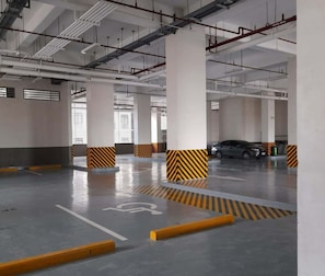 Eine mehrstöckige Parkgarage mit deutlicher Beschilderung, darunter ein Stellplatz für Menschen mit Behinderung.