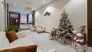 Un moderno vestíbulo de hotel con una recepción, un árbol de Navidad y zonas de estar cómodas.