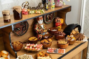 Uma mesa de buffet com diversos alimentos e elementos decorativos.
