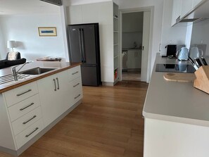 A modern kitchen with a stainless steel refrigerator, wooden countertop, and a view into the dining area. - Gulls Way, one of the best views in Paynesville (Paynesville)