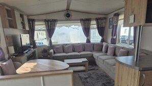 Ein kompaktes Wohnmobil-Interieur mit einer Sitzecke, einem kleinen Tisch und einer Küchenzeile.