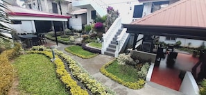 Un patio central con escaleras, rodeado de plantas y una zona de estar.