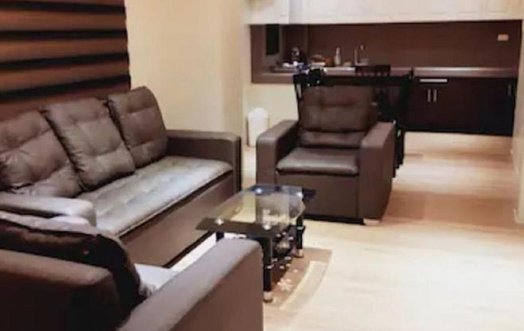 Un salon avec un canapé, un fauteuil et une table basse.