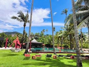 A pool area with lounge chairs and a red structure.