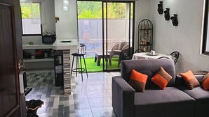 En moderne stue med sofa og spiseplads.