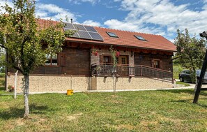 A rustic house with a tiled roof, solar panels, a stone facade, and a small balcony. - Gorgeous home in Tugonica with WiFi (Tugonica)
