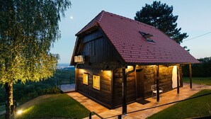 Eine Holzhütte mit rotem Dach, einem Balkon und einer überdachten Veranda.