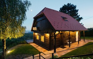 Eine Holzhütte mit rotem Dach, einem Balkon und einer überdachten Veranda.