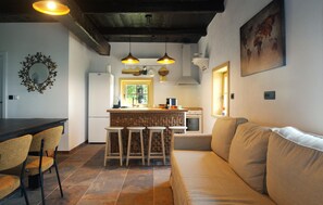 A modern kitchen with a central island, bar stools, and pendant lighting.