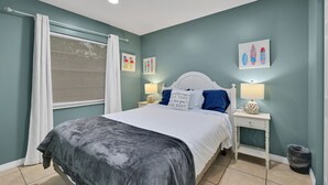Ein Schlafzimmer mit Bett, Nachttischen und Wandbildern.
