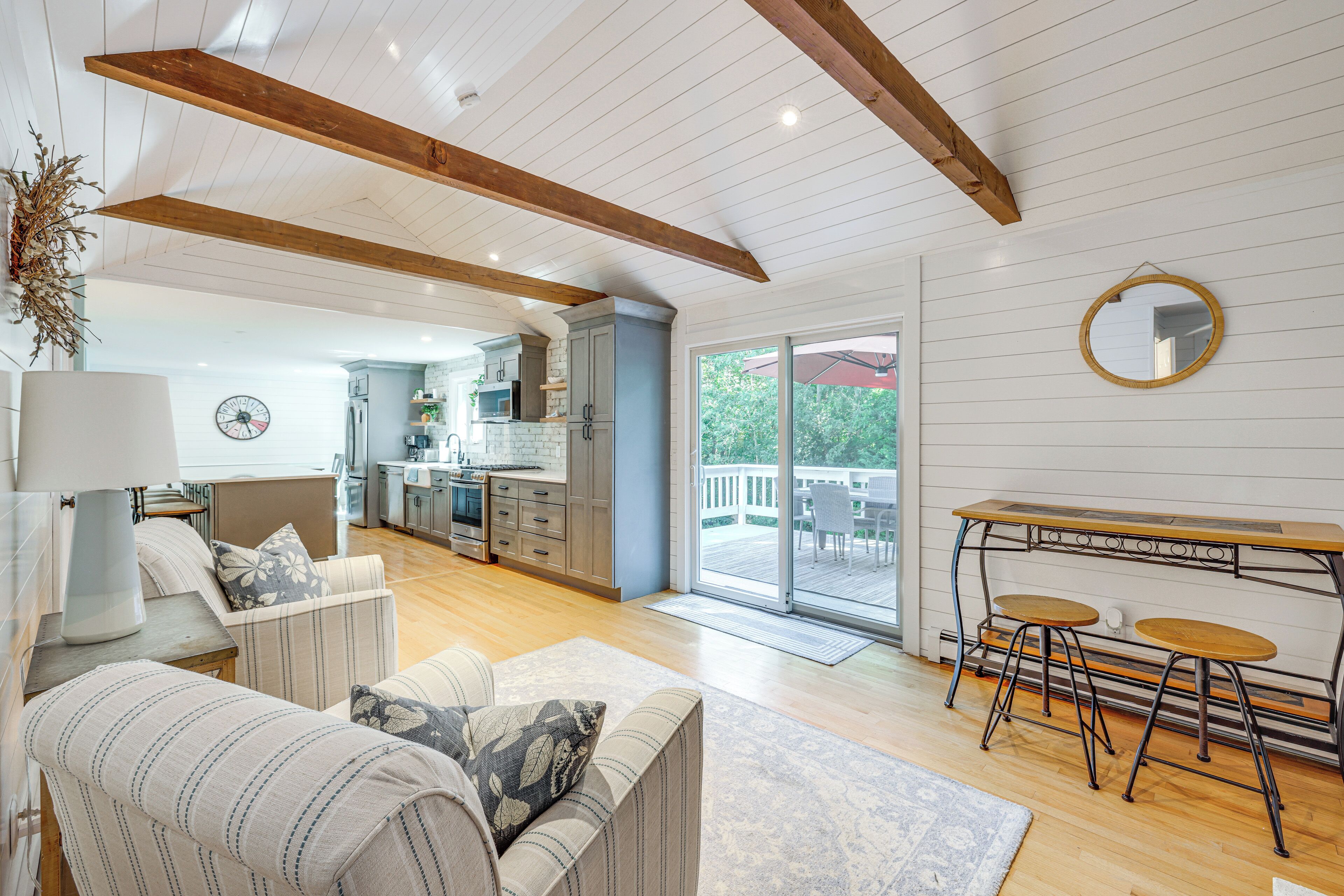 A spacious living area with a sofa, a dining table with chairs, and a kitchen in the background.