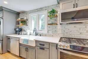 A modern kitchen with a stainless steel refrigerator, double sink, and a gas stove. - Minutes Away From the Best Beaches in Cape Cod! (South Dennis)