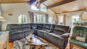 A spacious living room with a large sectional sofa, a wooden coffee table, and a rustic rug. - Walk to Beach! Home w/ Sunroom in Anchor Bay (Gualala)