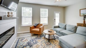 A living room with a sofa, armchair, coffee table, and a ceiling fan. - Walk to Convention Center & Ocean! Extended Escape (Virginia Beach)