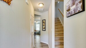 A hallway with a carpeted staircase, a ceiling light, and a framed picture on the wall. - Walk to Convention Center & Ocean! Extended Escape (Virginia Beach)