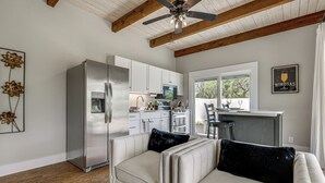 A modern kitchen with white cabinets, stainless steel appliances, and a ceiling fan. - Hot Tub & Fire Pit! Texas Wine Country Retreat (Fredericksburg)