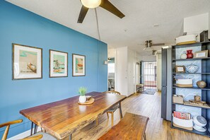 A dining area with a wooden table and chairs, framed artwork on the wall, and a ceiling fan. - Free Parking! Waikiki Condo, 3BR, 5BDs, Sleeps 6! (Honolulu)