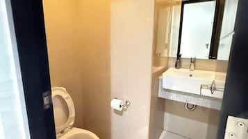 Baño con inodoro, lavabo y espejo.