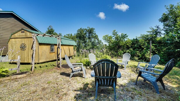 A wooden structure with a green roof, surrounded by gravel and greenery, with Adirondack chairs arranged for seating. - < 1 Mi to Dtwn Gatlinburg! Home w/ Hot Tub & Views (Gatlinburg)