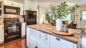A modern kitchen with white cabinetry, a stainless steel refrigerator, a built-in oven, and a wooden countertop. - < 1 Mi to Dtwn Gatlinburg! Home w/ Hot Tub & Views (Gatlinburg)