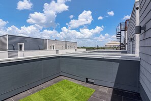 A rooftop terrace with a flat roof, a small grassy area, and a view of the city skyline. - Walk to Astrodome! Houston Home w/ Balcony (Houston)
