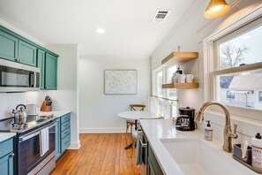 A modern kitchen with teal cabinets, a white countertop, and a wooden floor. - 1 Mi to Dtwn Tyler! Historic Retreat + Guest Suite (Tyler)