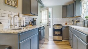Uma cozinha moderna com lava-louças, fogão e máquina de café.