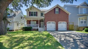 A two-story house with a front porch, a brick facade, and a driveway leading to a garage. - 1 Block to Beach + Private Patio in Norfolk (Norfolk)