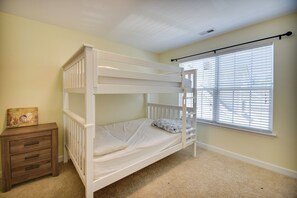 A bunk bed in a room with a window, a bedside table, and a carpeted floor. - 1 Block to Beach + Private Patio in Norfolk (Norfolk)
