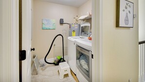 A laundry room with a washing machine, a dryer, a vacuum cleaner, and a radiator. - 1 Block to Beach + Private Patio in Norfolk (Norfolk)