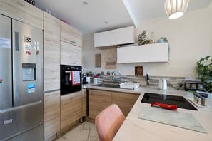 A modern kitchen with a built-in oven, a water dispenser, and a stainless steel refrigerator. - Sea View 2 Bed & 2 Bath - Highly Rated, with Wi-Fi and Air Conditioning (Nice)
