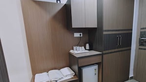 A compact room with a kitchenette, a small fridge, a sink, and a cabinet with a towel rack. - Rimjhim Water Kingdom & Resort (Mandar)