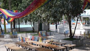 An outdoor seating area with tables and chairs, surrounded by trees and a view of a body of water. - Rimjhim Water Kingdom & Resort (Mandar)