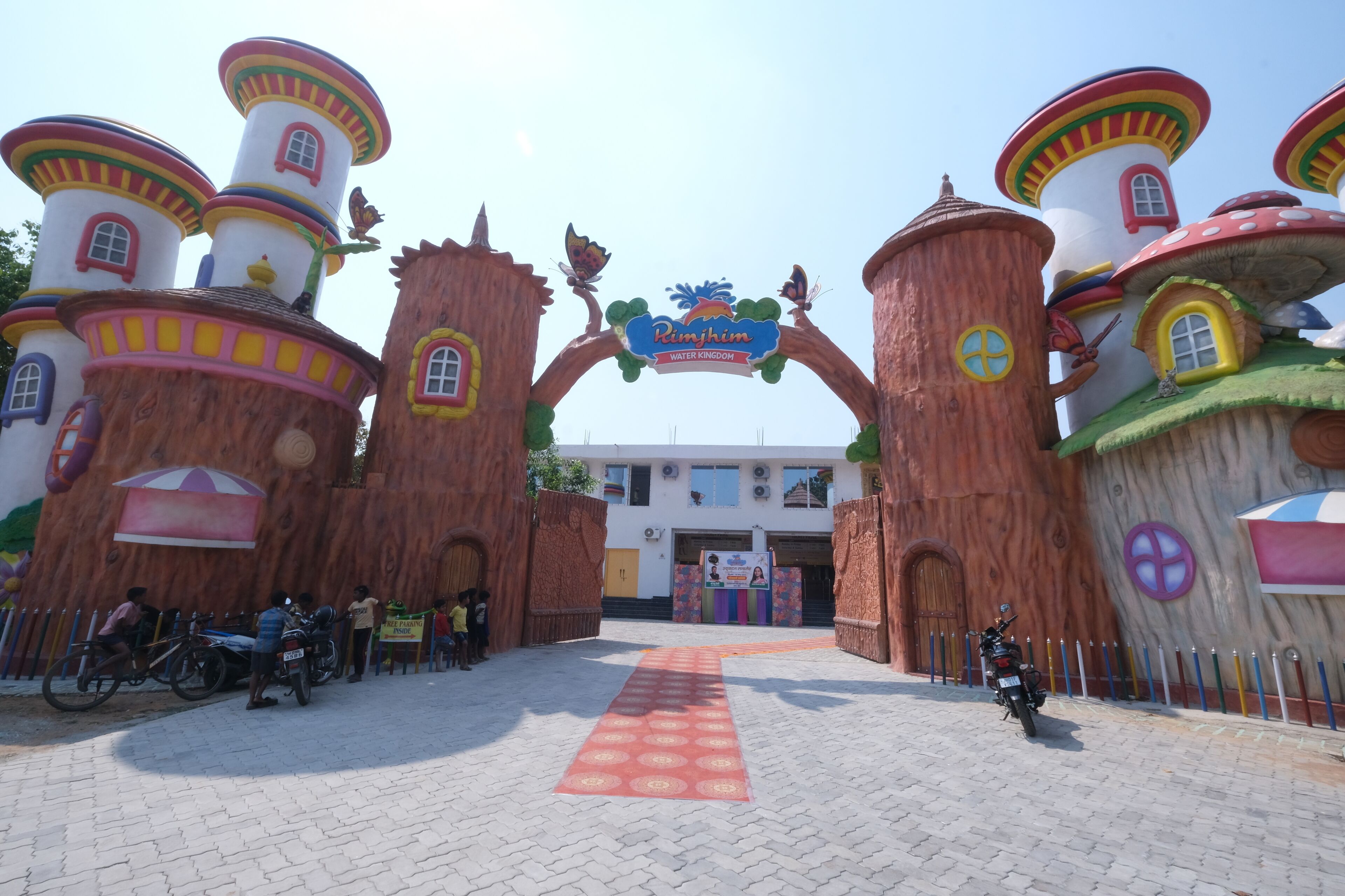 A whimsical entrance with colorful buildings and a sign reading 'Pimjhim Water Kingdom.'