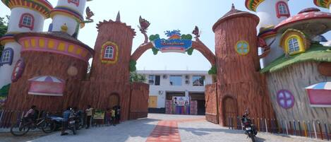 Una entrada pintoresca con edificios coloridos y un letrero que dice 'Pimjhim Water Kingdom'.