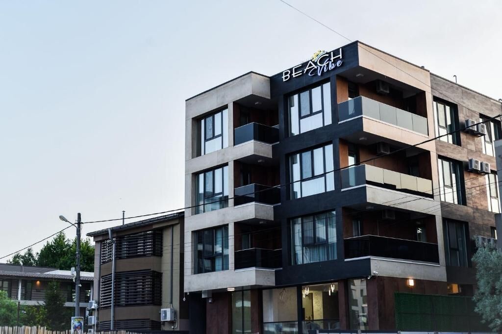 Un edificio de varios pisos con un letrero que dice 'Beach Vibe'.