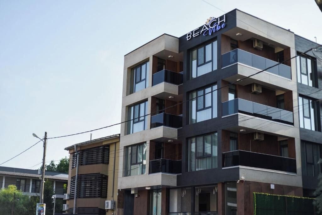 A multi-story hotel with a modern design, featuring balconies on each floor.