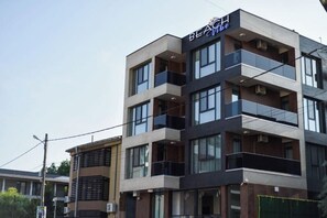 Un hotel de varios pisos con un diseño moderno, que cuenta con balcones en cada planta.