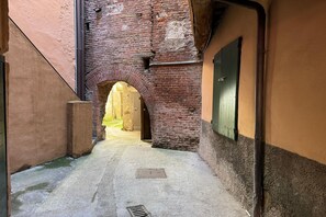 A narrow alleyway with a brick archway leading to a courtyard. - A Bright and Cozy Apartment with Stunning Views in the Heart of Lucca (Lucca)